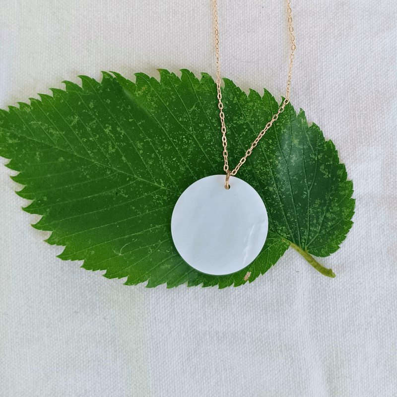 1-inch mother of pearl and copper necklace on a green leaf, handmade by Cherokee Copper