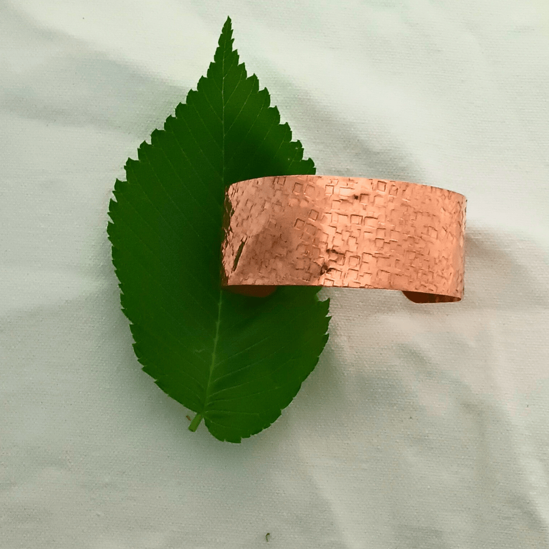 Hand-hammered copper cuff bracelet on leaf