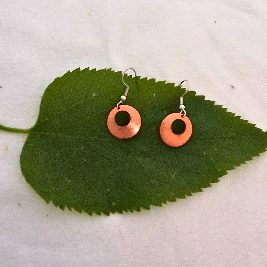 Nora earrings by Cherokee Copper on green leaf