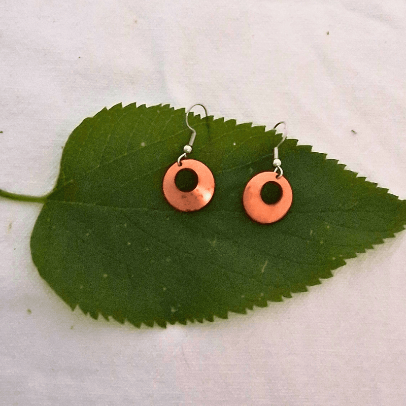 Nora earrings by Cherokee Copper on green leaf